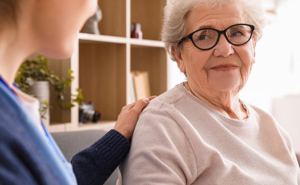 A nurse is speaking with an elderly woman.