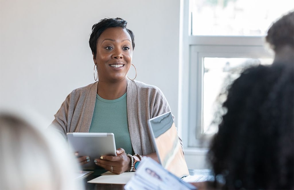 A woman is shown leading a meeting