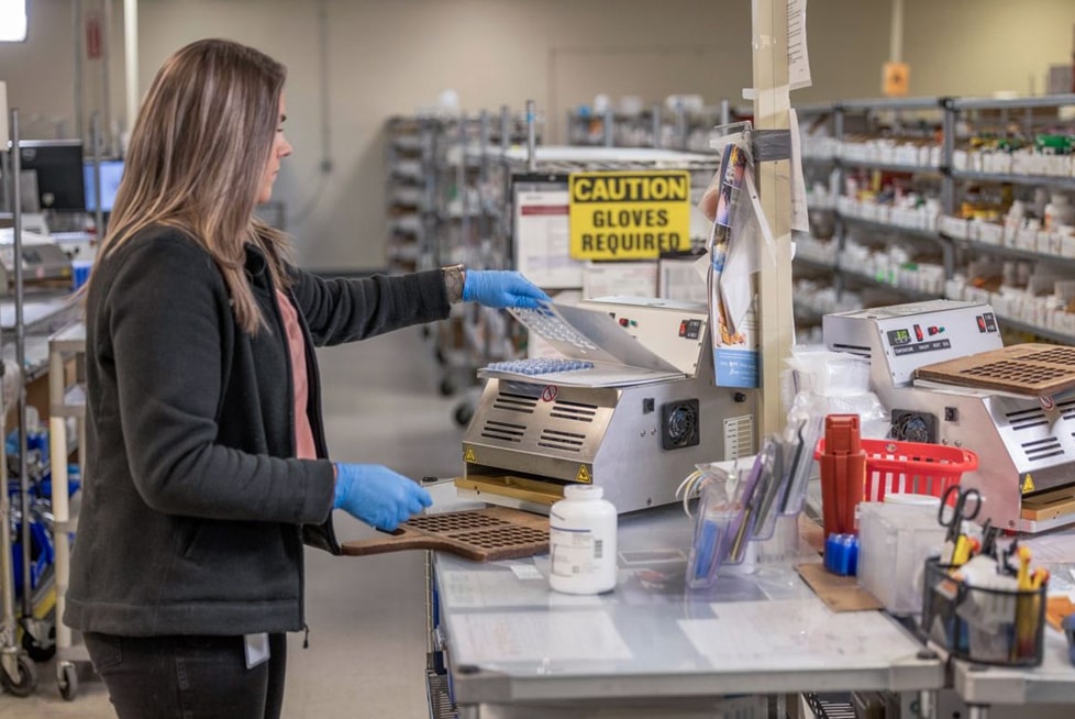 A worker is packing medications in a warehouse