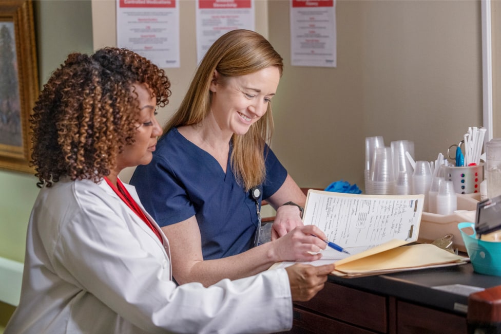 A Doctor and Healthcare worker are reviewing documents