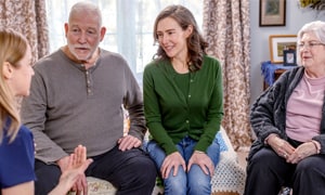 Four people are sitting on a couch having a discussion