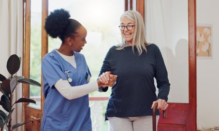 A nurse helping a woman walk